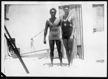 Black and white photograph of two men in bathing costumes posing together