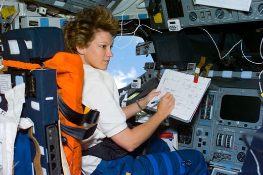 Collins consults a checklist in the commander's seat