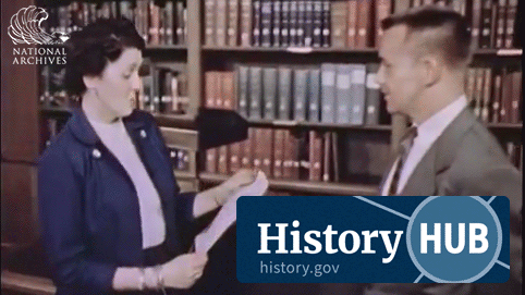 animated GIF of a researcher and an archivist looking over a document with books and shelving in the background